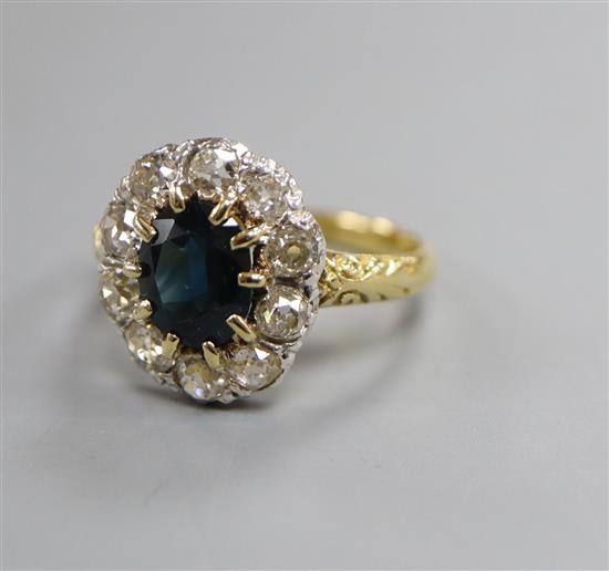 An 18ct, sapphire and diamond set oval cluster ring, size O.